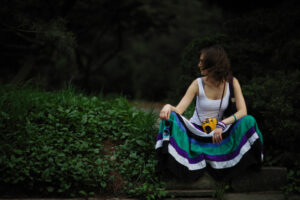 Woman kneeling with camera on grass verge