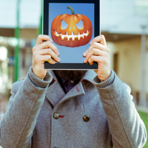 Man holding iPad with pumpkin on the screen